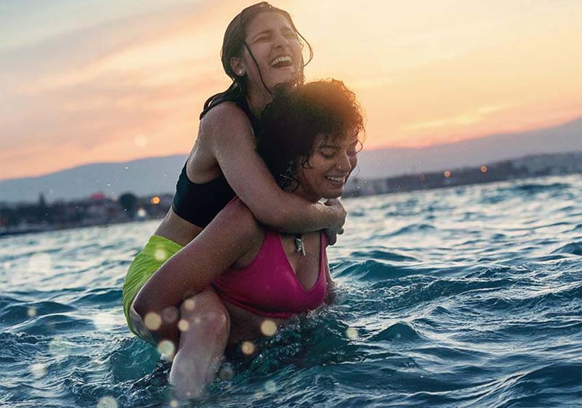 Poster detail. Two girls in the sea one on top of the other